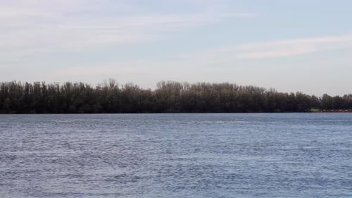 Die Regenzeit an der Donau. Schnell fliegende überflutete Donau an einem bewölkten Tag
.
