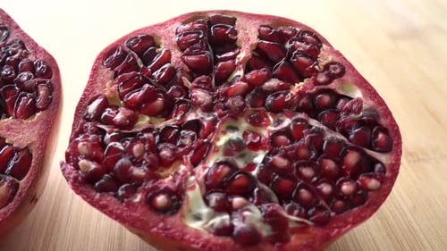 Rotating pomegranate fruit and seeds, top view, 4K