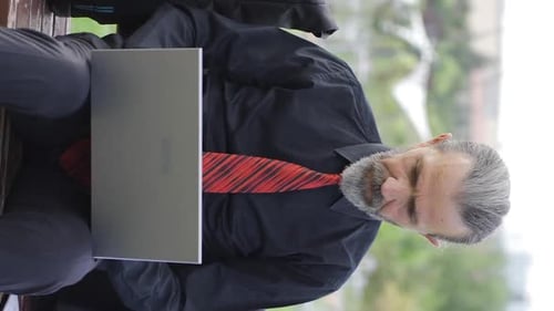 Middle-aged Man Works on Laptop in Urban Setting