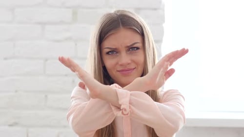 Young Woman Expressing No With Crossed Arms