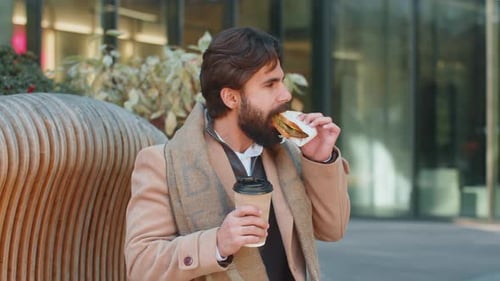 Indian Young Businessman Tourist Enjoy Lunch Break Eating Sandwich and Drinking Hot Coffee or Tea