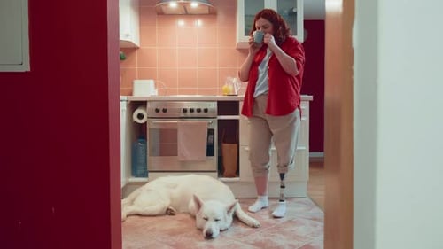 Copy Space Shot Beautiful Happy Woman with Bionic Prosthetic Leg Using Smart Phone in Kitchen with