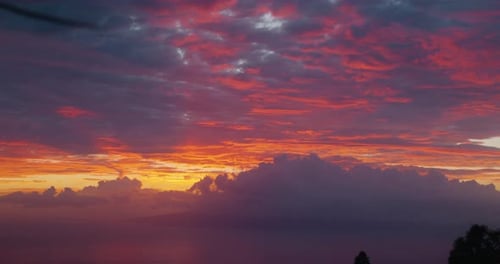 Sunset sky with crimson sunlight shining clouds. Flamboyant dramatic dusk.
