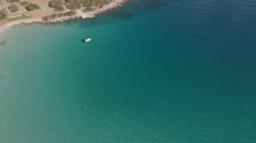 Weißes Boot im türkisfarbenen Wasser auf Kreta