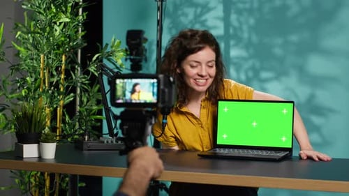 Woman Presents Laptop With Green Screen in Studio