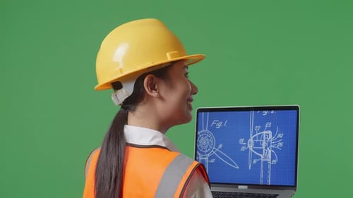 Close Up Of Female Engineer Looking At The Wind Turbine Blueprint On Laptop In The Green Screen