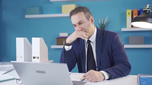 Businessman stressed about jobs in overwhelmed mood at office.