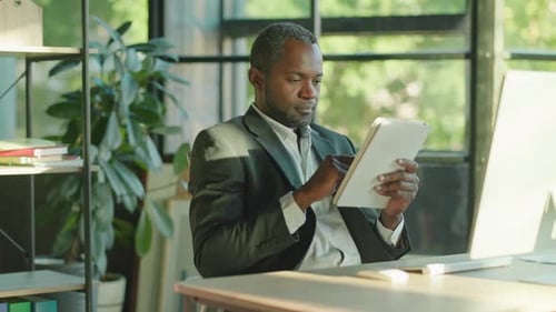Portrait Handsome Happy African American Man with a Beard Working Using a Tablet Computer Looking at