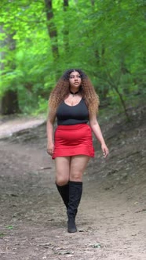 Latin American young woman walking in the forest