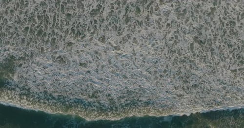 Aerial view of drone flying above beautiful beach with views of ocean waves