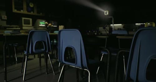 Dark Classroom Projector Light Beam with Empty Desks