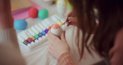 Mother and Daughter are Painting Easter Eggs for Easter Holidays