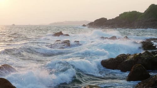 Sunset Over Ocean As Waves Crash on Rocky Shore Sea Spray Foam in Air Natural Scene Coastline