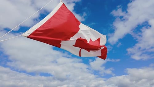 Canadian Flag Waving Proudly Against a Blue Sky