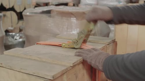 Trabalhador de armazém usando equipamento especial preparando caixa de madeira para envio