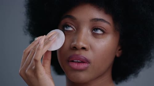 Closeup of Beautiful African American Girl Model Cleaning Her Face From Makeup with Lotion and