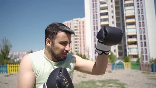 Man Boxing in Urban Park