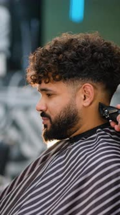 Man with Curly Hair Getting Haircut in Barbershop