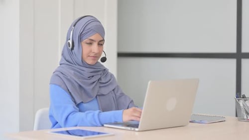 Muslim Woman in Hijab with Headset Smiling at Camera in Call Center