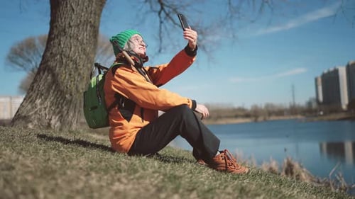 Greyhaired Woman in Activewear Taking Selfie on Shore of Pond in City Park Healthy Lifestyle and