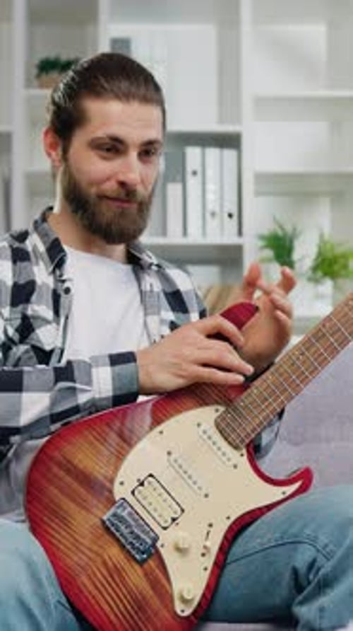 Man Explains Electric Guitar Details in a Home Setting