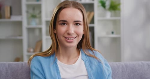 Smiling Young Woman Sitting Indoors on Couch