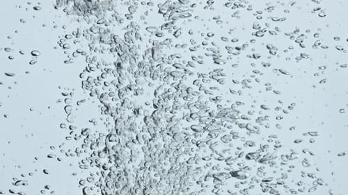 Bubbles rising in clear water with blue background