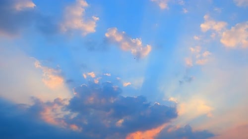 Sun Rays Streaming Through Fluffy Clouds at Sunset
