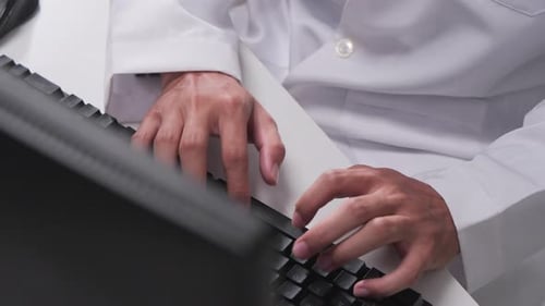 Nahaufnahme der Hände des Arztes beim Tippen auf die Computertastatur, Telemedizin aus der Ferne.