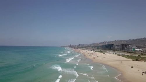 Beautiful sandy beach with people and colourful umbrellas - Aerial footage
