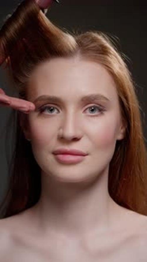 Closeup of Woman's Face with Hair Being Curled By Pink Curling Iron Professional Hairstyling Beauty