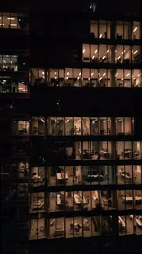 Closeup of an Office Building with Illuminated Offices Shining Bright at Night