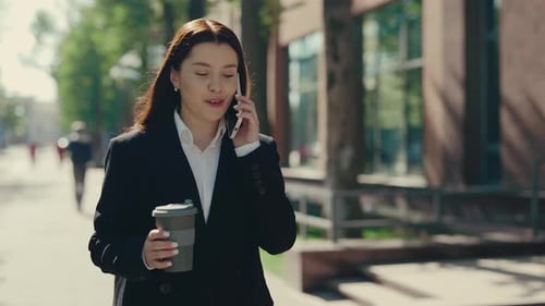 Happy Business Woman in Formal Suit Going Near the Business Center Speaking on the Phone with