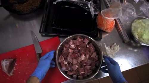 Chef Prepares Diced Meat in a Commercial Kitchen