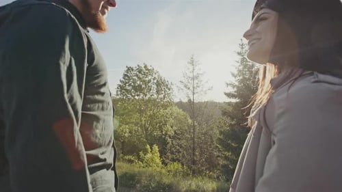 Two Hikers at Viewpoint in the Mountains Enjoying Beautiful View of the Valley with a Lake and Sunny
