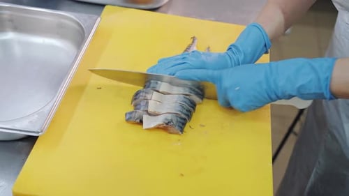 Chef Cuts Fish Fillet on Yellow Cutting Board