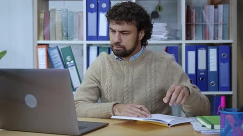 Male Manager Working in the Office Writing Down Notes Using Corporate Notebook at Desk Portrait of