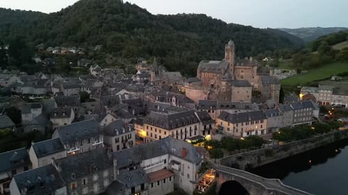 Drone aerial view in France countryside small old medieval town and a castle over stone bridge on a