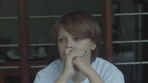 Chica triste sentada y mirando a la distancia de cerca