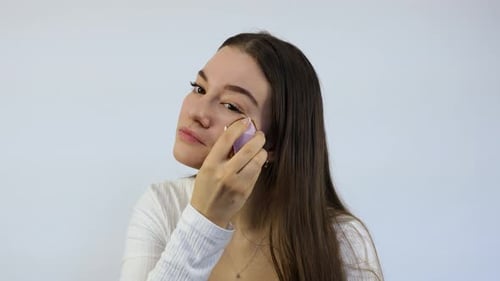 Woman Applying Makeup Foundation with Applicator