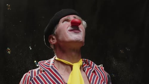 Clown Performing with Bubbles in Dark Studio