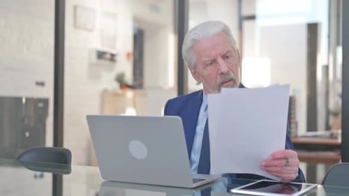 Senior Businessman Celebrates Good News at His Desk