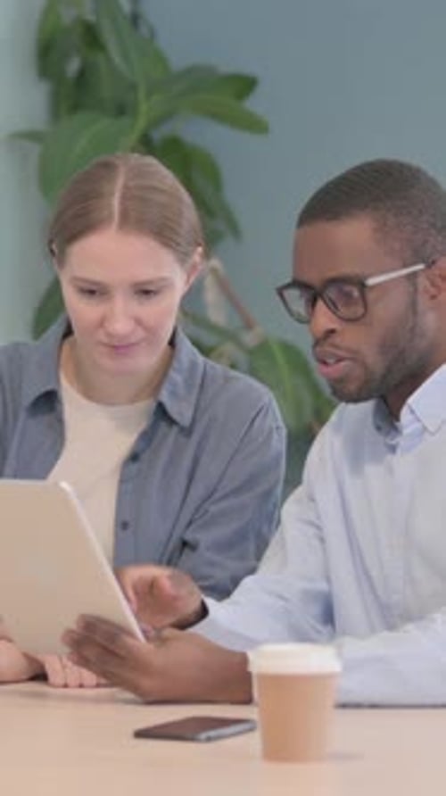 Young Business People Discussing Work on Tablet in Office, vertical video