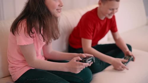 Children Playing Video Games on Couch at Home