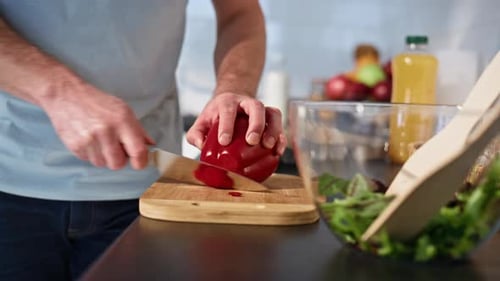 Man Slicing Red Pepper for Salad in Kitchen