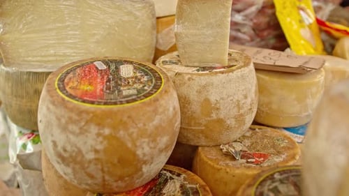 Pile of matured delicious cheese in local market, dolly backward shot