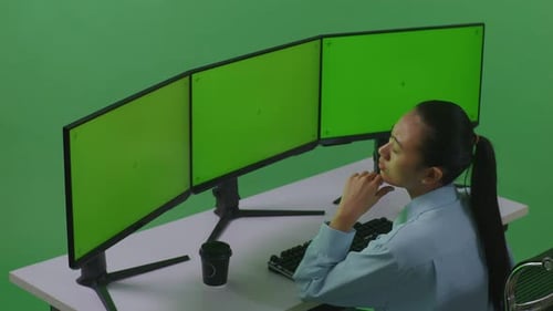 Asian Woman Thinking While Working With Mock Up Multiple Computer Monitor In Green Screen