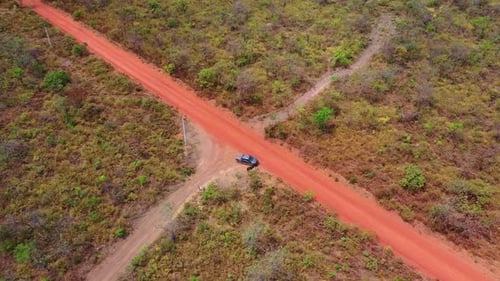 Top‑Down Drone Spin Above Red Dirt Crossroads With 4x4 in Tocantins Cerrado, Brazil