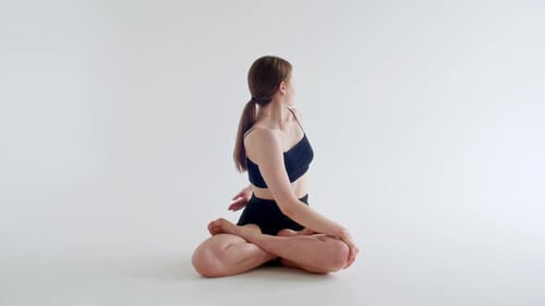 Woman Practicing Yoga in White Studio