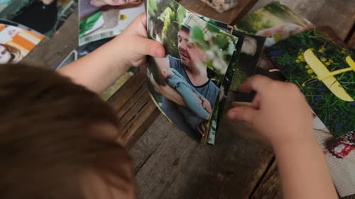 Impresión de fotografías: recuerdos familiares, niño en edad preescolar mirando fotos impresas